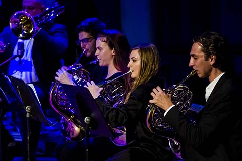 Brass section of the Jazz band dressed in black plays during a performance on stage