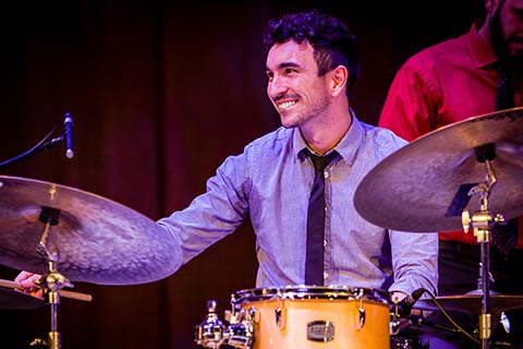 Drummer smiling while performing during an event