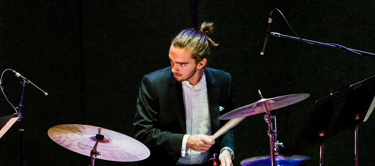 Drummer looks to his right while behind the drums during a performance