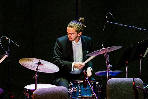 Drummer looks to his right while behind the drums during a performance