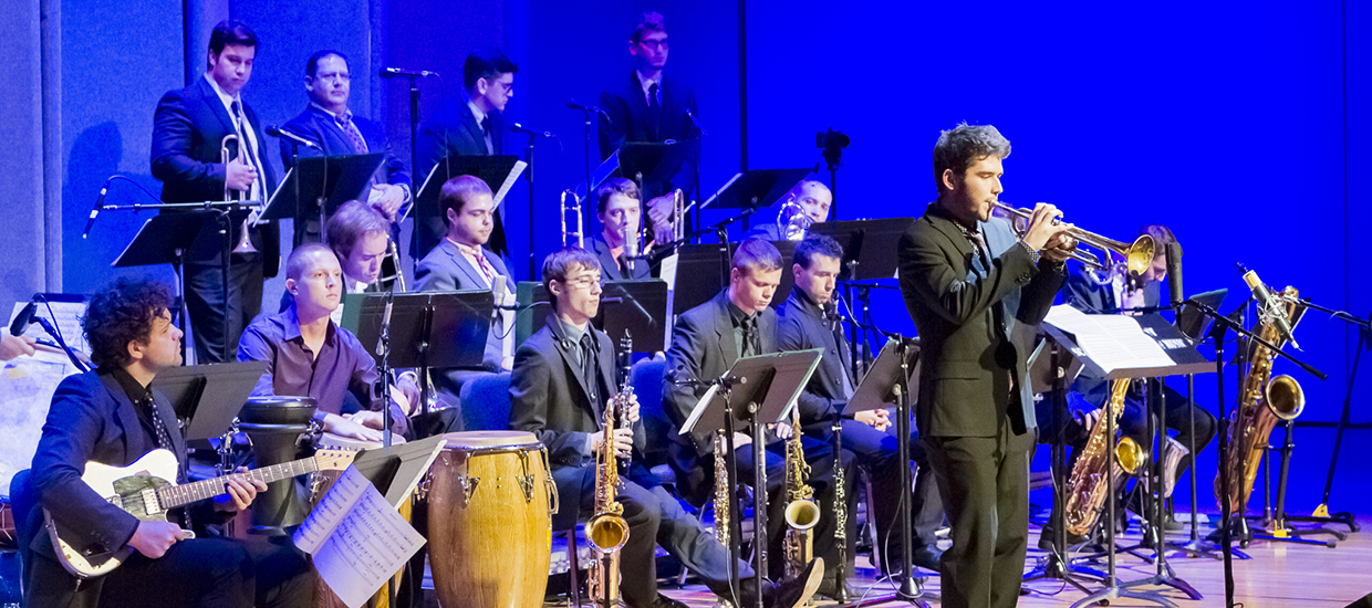 Trumpet player performs a solo while the jazz band takes a moment to rest on stage