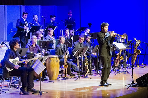 Trumpet player performs a solo while the jazz band takes a moment to rest on stage